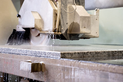 Zuschnittmaschiene der Firma Löseke´s Steingarten beim Zuschneiden einer Natursteinplatte.