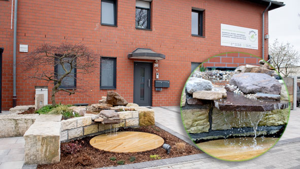 Ein gestaltetes Wasserspeil mit einem kleinen Wasserfall vor dem Gebäude der Fiorma Löseke´s Steingarten.